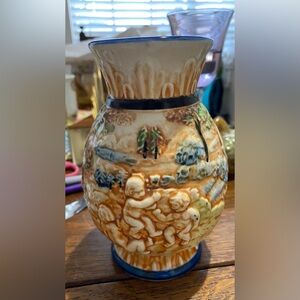 This item is a 1935 Vtg porcelain vase featuring a raised relief design Cherubs.